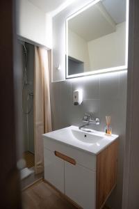 a bathroom with a white sink and a mirror at Verslo Klasė-easy to stay in Panevėžys