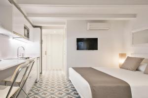 een witte slaapkamer met een bed en een wastafel bij Uma Suites Sagrada Familia in Barcelona