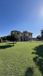 a large house in a field of green grass at Suites Mansion in Rozzano