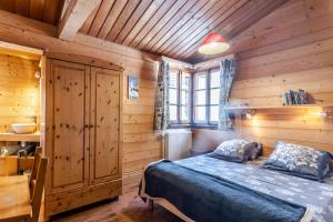 a bedroom with a bed in a wooden room at chalet les ecureuils in Saint-Jean-de-Sixt