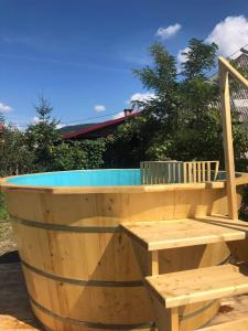 a wooden barrel pool with a table and a bench at Pensiunea Brezu in Sighetu Marmaţiei