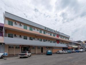 ein Hotel mit Autos auf einem Parkplatz in der Unterkunft Royal Hotel in Keningau