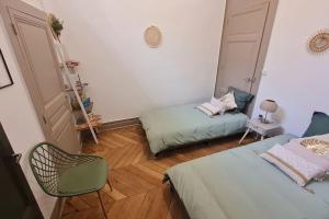 um quarto com duas camas e uma cadeira em L'Escapade Bohême em Vienne