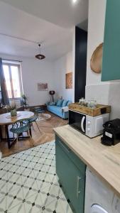 a kitchen with a counter top with a microwave at L'Escapade Bohême in Vienne