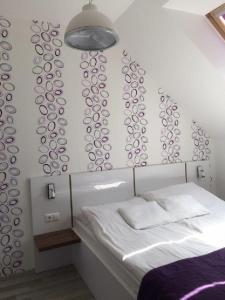Un dormitorio con una cama y una pared con círculos. en ALOE Apartman, en Sárvár
