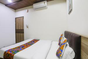 a bedroom with a white bed and a heater at FabHotel Vedanta Inn in Nagpur