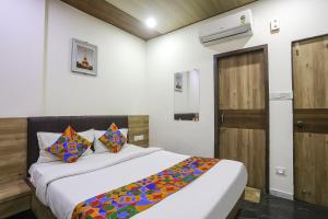 a bedroom with a bed with a colorful blanket on it at FabHotel Vedanta Inn in Nagpur