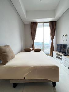 1 dormitorio con cama grande y ventana grande en 2BR 36 Taman Anggrek Residence Best Cozy and Stay Wifi 50mbps and Netflix Provided, en Yakarta