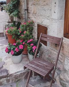 una silla de madera sentada junto a macetas de flores en Pensión liebana, en San Vicente de la Barquera