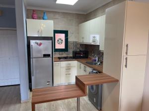 a kitchen with white cabinets and a refrigerator at Lahacienda Two bedroom chalet with roof in Ras Sedr