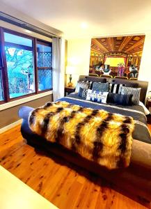 a bedroom with a bed with a faux fur blanket at Bowral Road Art Gallery Bed and Breakfast in Mittagong