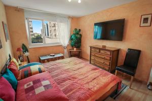 - une chambre avec un lit et une télévision à écran plat dans l'établissement Super appartement au coeur de Martigny, à Martigny-Ville