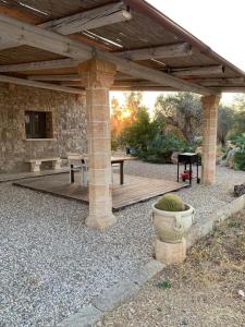 eine Holzterrasse mit einem Tisch und einer Bank unter einem Pavillon in der Unterkunft Villa Miliceddu in Tricase