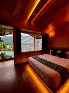 een slaapkamer met een bed in een kamer met een raam bij Aman The Lake Side Hotel in Nainital
