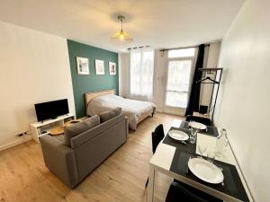 ein Wohnzimmer mit Sofa und Bett in der Unterkunft Appartement - Bourges in Bourges