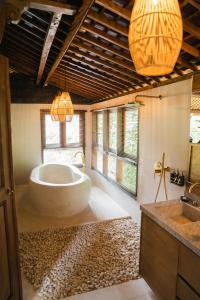 baño con bañera grande y lavamanos en Ubud Riverside Villa, en Ubud