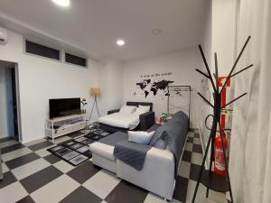 a living room with a couch and a tv at Santa Luzia Center in Ribeira Grande