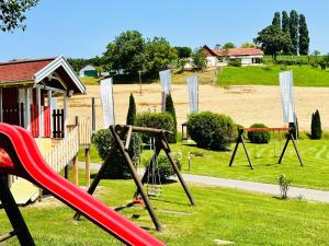 a playground with a slide and a swing set at Familien Hotel Krainz in Loipersdorf bei Fürstenfeld