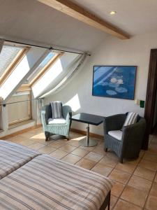 a bedroom with two chairs and a table and windows at PAULIS Vakantiehuis in Bullange