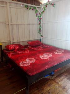 ein Bett mit roter Bettwäsche und roten Kissen darauf in der Unterkunft Kelong Bintan in Teluk Bakau