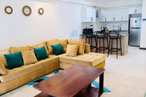 een woonkamer met een bank en een tafel en een keuken bij Yohana Residences in Nairobi