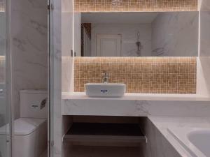een badkamer met een wastafel, een toilet en een spiegel bij CĂN HỘ CAO CẤP TẠI TRUNG TÂM QUẬN 1 in Ho Chi Minh-stad