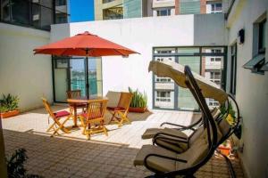 een terras met een tafel, stoelen en een parasol bij Yohana Residences in Nairobi