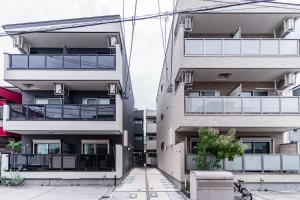 大阪市にある川HOUSE旭のバルコニーと中庭付きのアパートメントビル