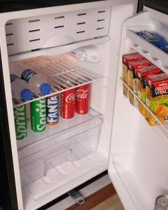 an open refrigerator filled with drinks and soda at Faletti's Express- Shimla Hill in Lahore