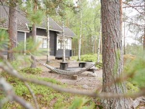 una hamaca frente a una cabaña en el bosque en Mökki Aapola, en Puumala