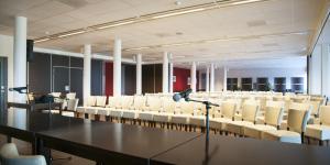 una sala conferenze con un lungo tavolo e sedie bianche di Bergwirtschaft Wilder Mann Hotel und Restaurant a Dresda