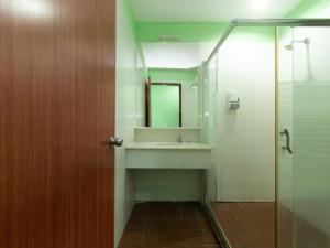 ein Bad mit einem Waschbecken und einem Spiegel in der Unterkunft Royal Hotel in Keningau