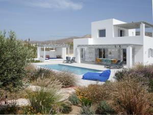 ein weißes Haus mit einem Pool davor in der Unterkunft Villa Aura in Kastraki Naxos