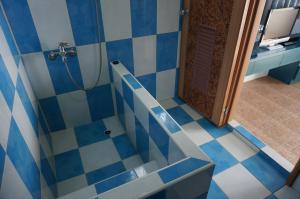 馬公市的住宿－觀星海民宿，蓝色和白色瓷砖浴室配有淋浴