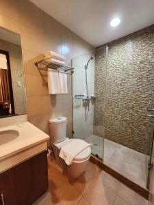 ein Bad mit einer Dusche, einem WC und einem Waschbecken in der Unterkunft The Padgett Suites in Cebu City