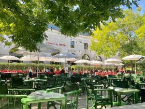 a group of green tables and chairs with umbrellas at Le Volta - studio proche gare in Sainte-Savine