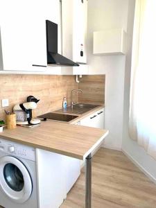 a kitchen with a sink and a washing machine at Le Volta - studio proche gare in Sainte-Savine +14 photos