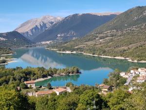 vistas a un lago con montañas en el fondo en La Tana degli Orsetti, en Barrea