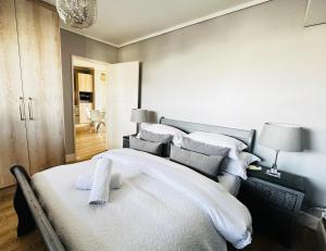 ein Schlafzimmer mit einem großen Bett mit weißer Bettwäsche und Kissen in der Unterkunft WATERS EDGE 103 in Kapstadt