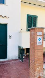 un pilar de ladrillo con una señal delante de un edificio en Sperlonga Sul Mare, en Sperlonga