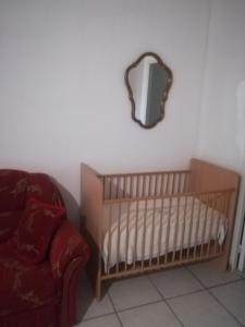 a nursery with a crib and a mirror on the wall at Au pays du Ventoux in Le Thor