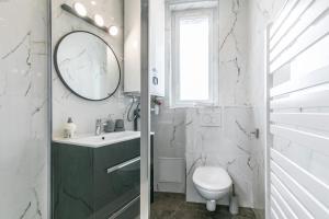 a bathroom with a sink and a toilet and a mirror at MBA Splendide Appart - Montreuil 5 - Proche Vincennes in Montreuil