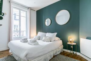 a bedroom with a large white bed and a mirror at MBA Splendide Appart - Montreuil 5 - Proche Vincennes in Montreuil