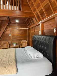 a large bed in a room with wooden walls at "Sakinah" Homestay Syariah AC in Sarilamak