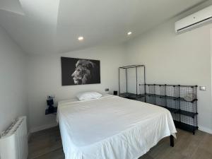 Un dormitorio con una cama blanca y una foto en la pared en manresa universidad, en Manresa