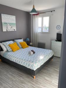 1 dormitorio con 1 cama con almohadas amarillas en Chambre les Hortensias, en Challans