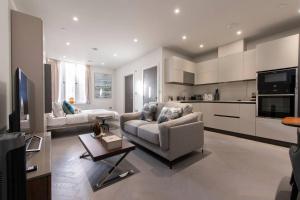 a living room with two couches and a kitchen at Central Reading Designer Studio in Reading