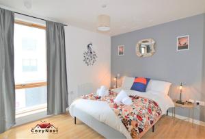 a bedroom with a bed and a large window at Elegant Central Self Contained Flat by CozyNest. in Reading