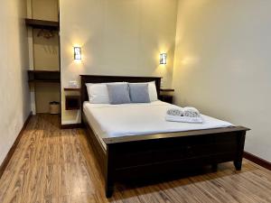a bedroom with a bed with white sheets and blue pillows at Harbour Bliss Hotel in Coron