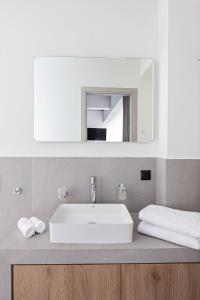 a bathroom with a white sink and a mirror at Airio Athens Suites in Athens